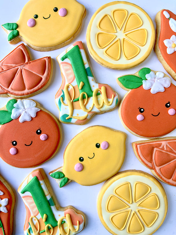 Hand-decorated cookies shaped like fruits and the number 1