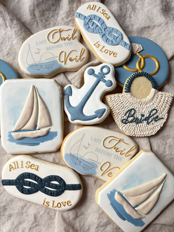 Hand-decorated cookies with nautical designs celebrating a wedding