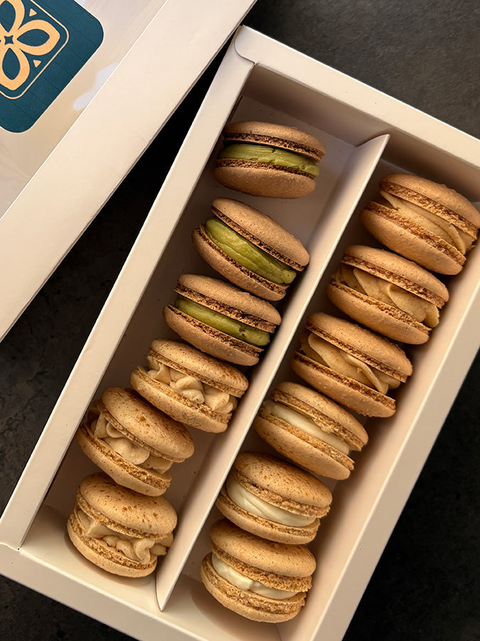 Box of macarons with a visible brand logo on a dark surface