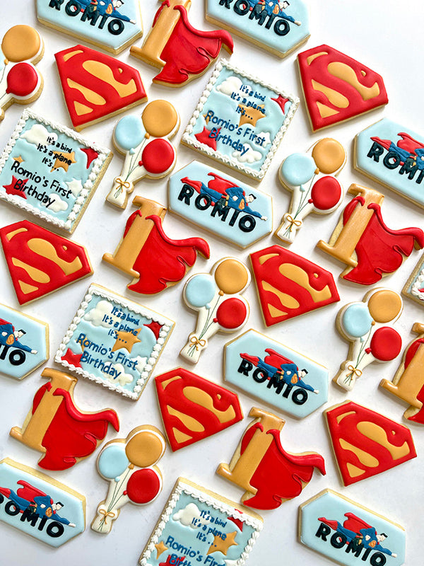 Cookies in the shape of the Superman S and cape for a child's first birthday