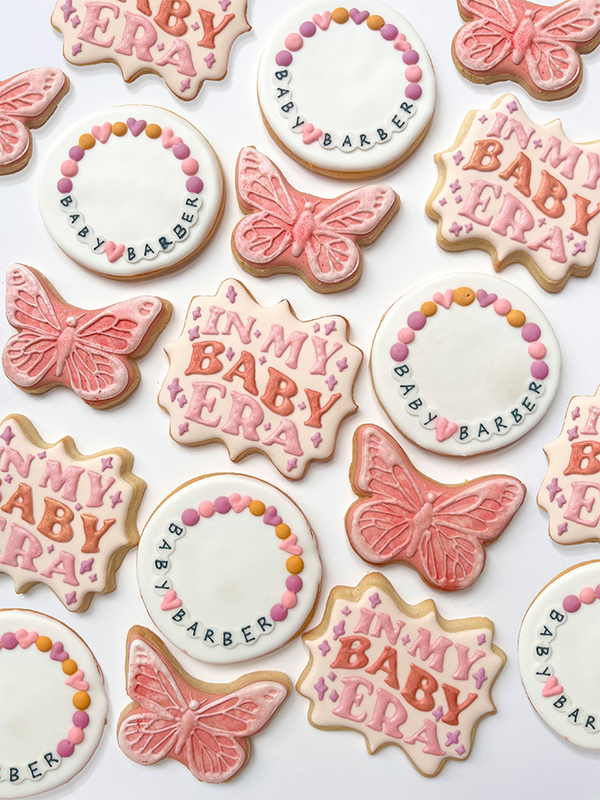 Decorative cookies with 'In My Baby Era' and butterfly designs on a white background